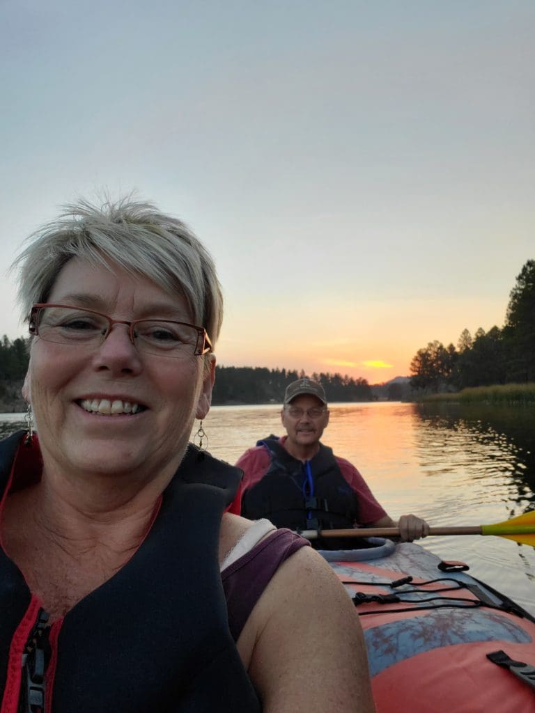 Tammy and Tim canoeing on a lake
