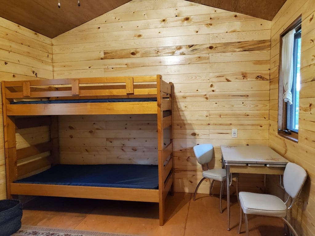 Interior of cabin two with table and seating and bunk beds
